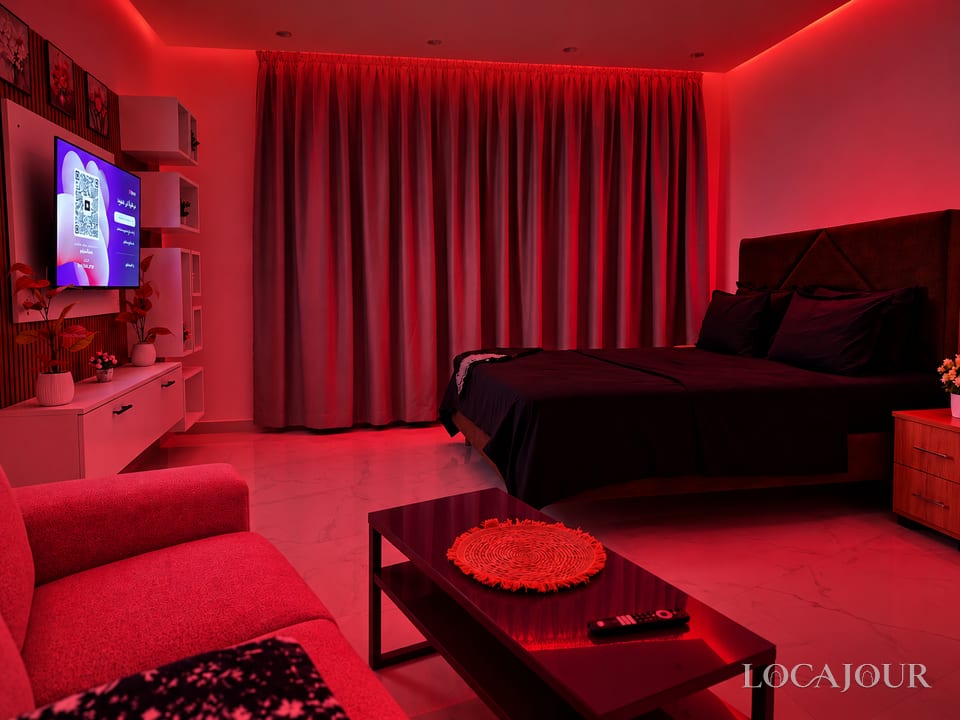 Modern luxury bedroom in Agdal Rabat with king bed TV ambient lighting and stylish furnished studio decor